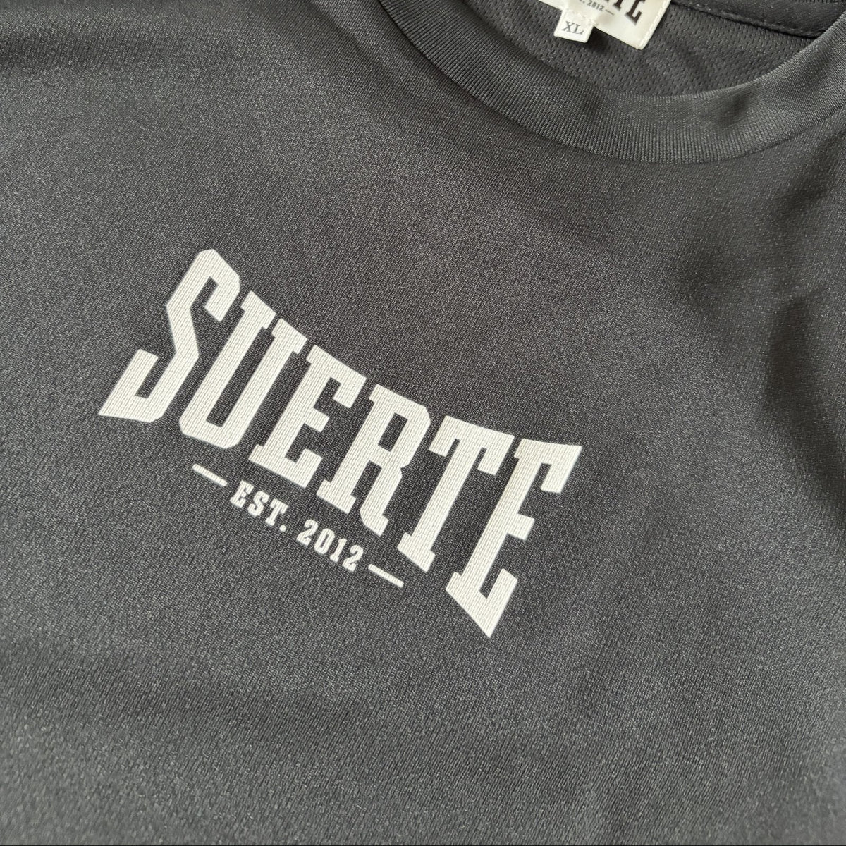 SUERTE ドライTシャツ 胸のアーチロゴ（EST. 2012）